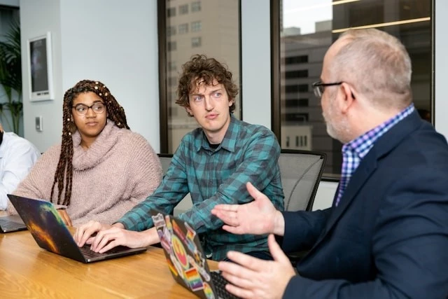 People with laptops having a discussion