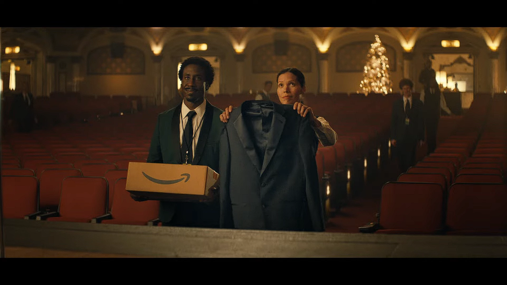 A coworker hands him the tuxedo