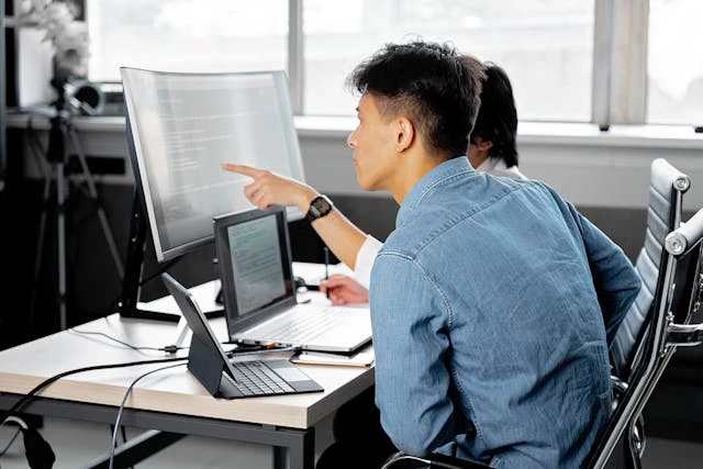 Men looking at computer monitor