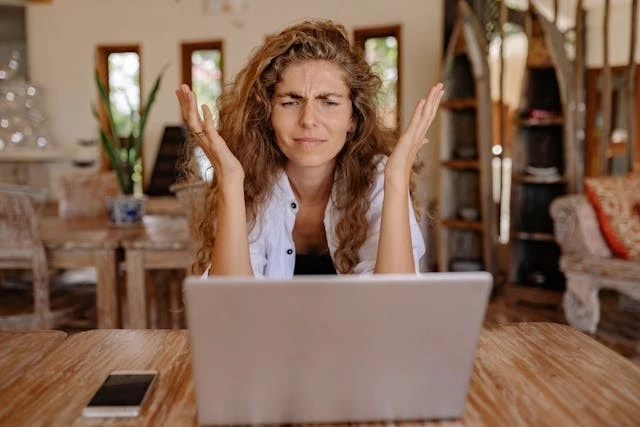 Frustrated woman looking at laptop
