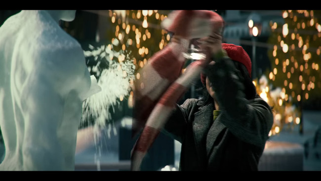 The woman breaks off the snowman's arm The woman breaks off the snowman's arm