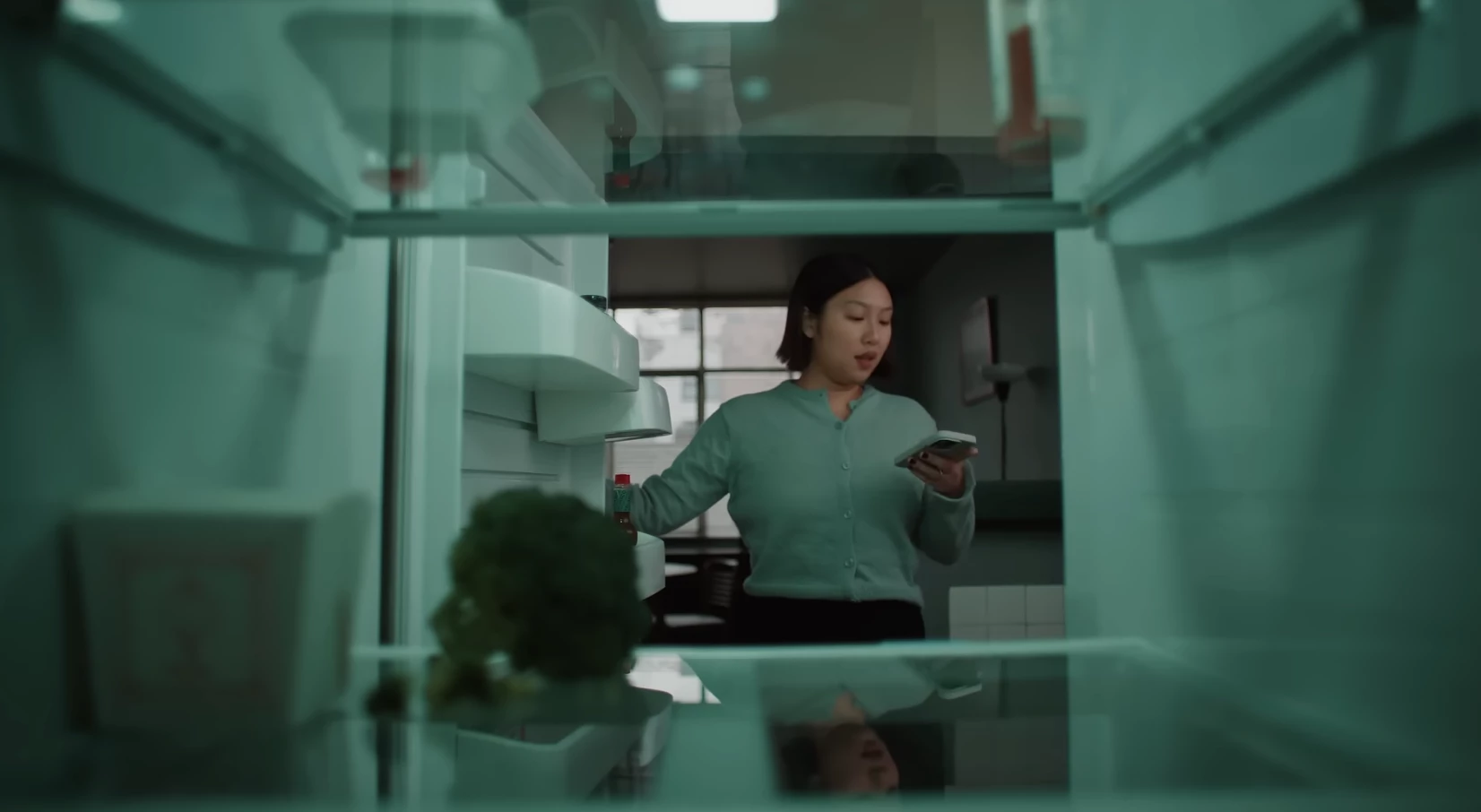 Big sister opening a near-empy fridge.