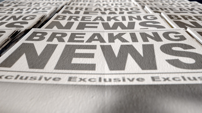 A printed newspaper that says “breaking news”