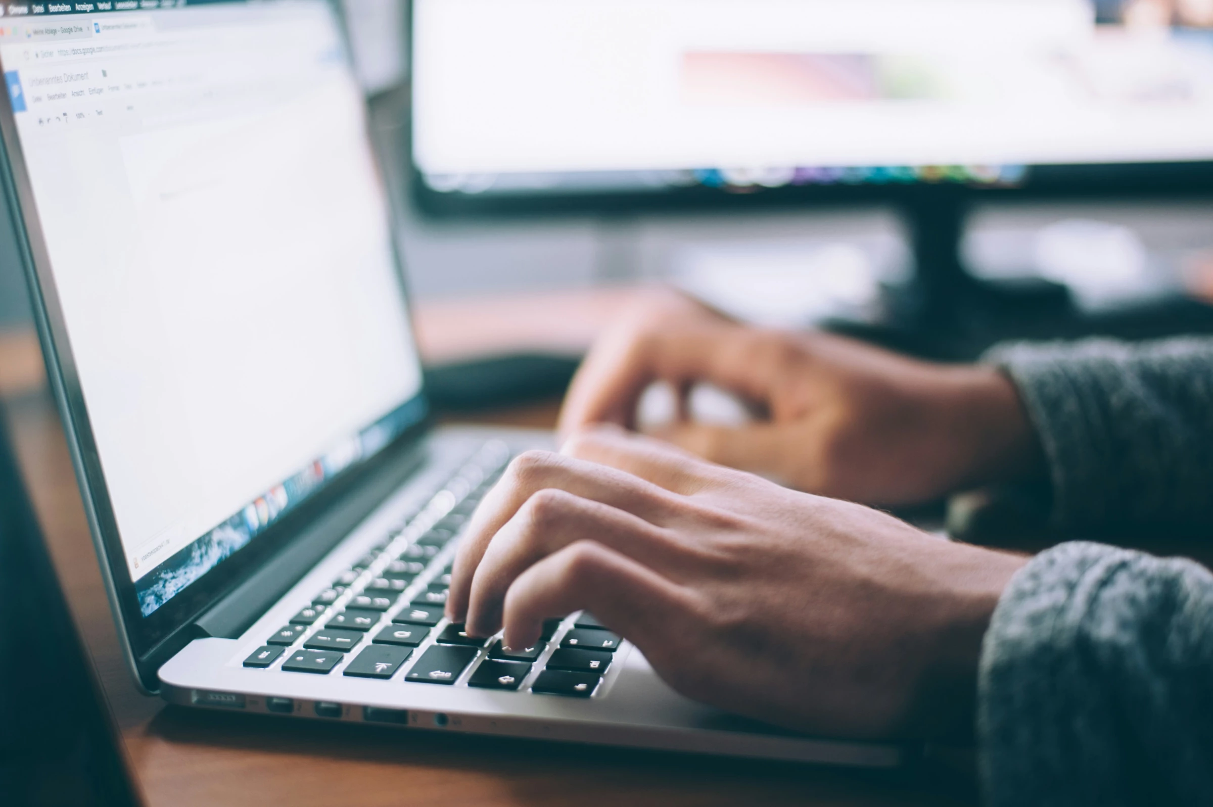 A copywriter types on a laptop