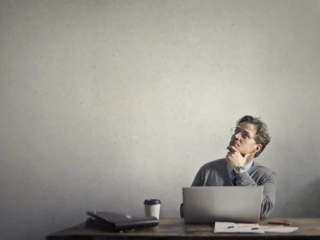Man with laptop thinking