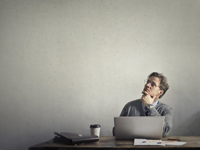 Man with laptop thinking