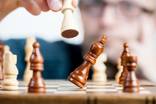 Person holding chess piece