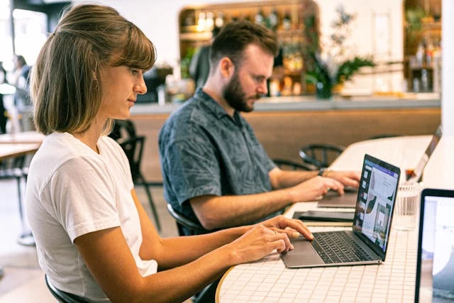 Woman and man using laptops
