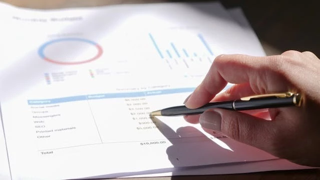 Person pointing pen at a report
