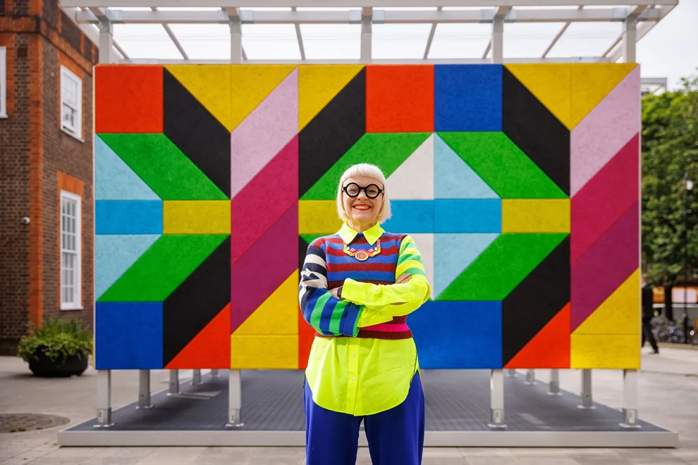 Morag Myerscough in front of her graphic design exhibit