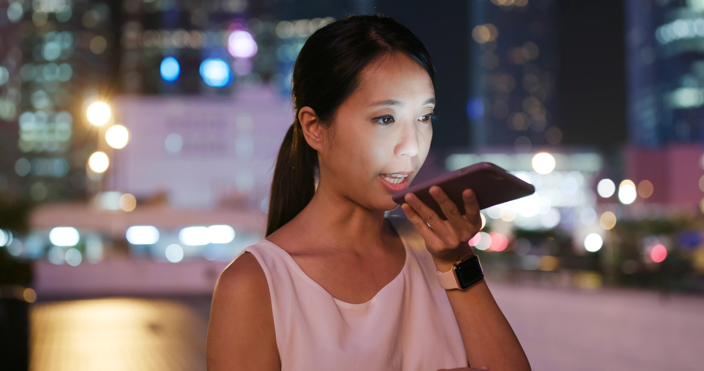 Woman uses voice search on a smartphone at night