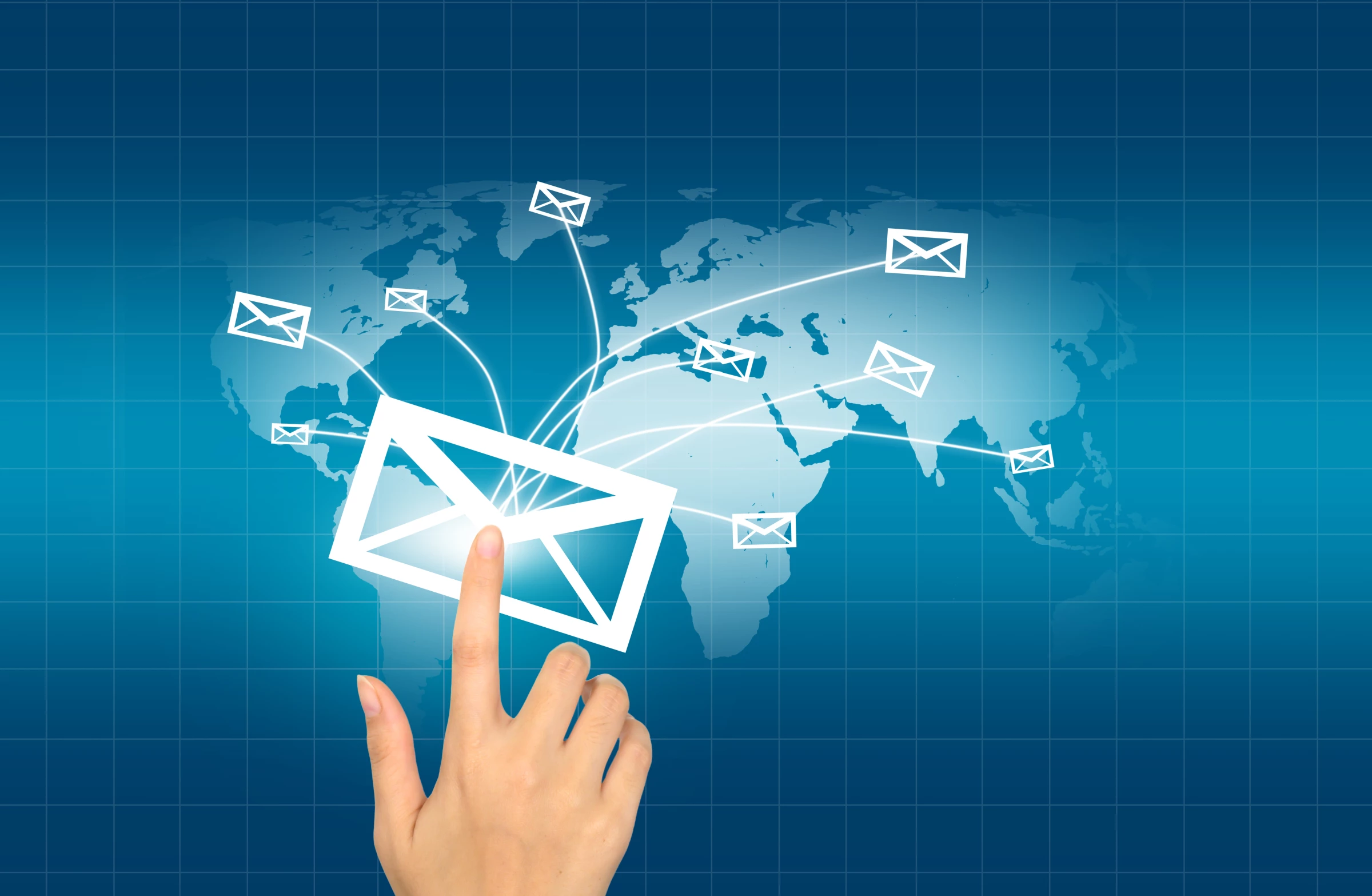 Hand touching a digital envelope icon with emails spreading globally on a blue world map