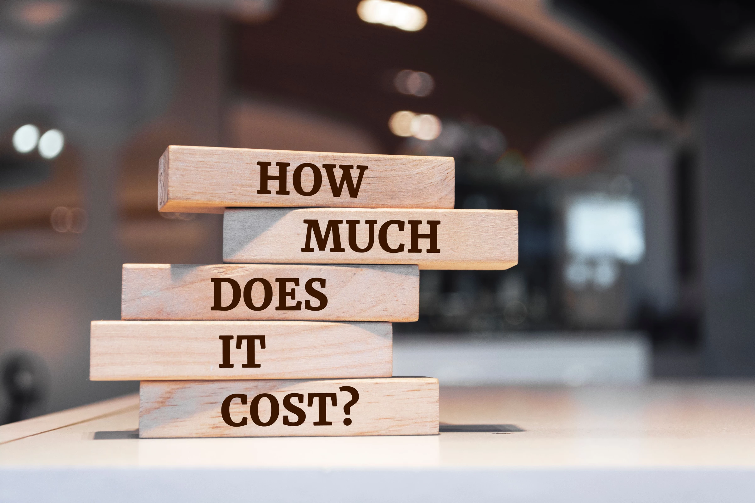 Wooden blocks with words 'How Much Does It Cost?