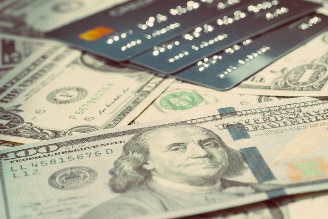 US dollar bank notes and a pile of credit cards