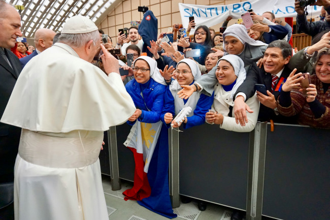 Pope Francis is surrounded by devotees in a past event.