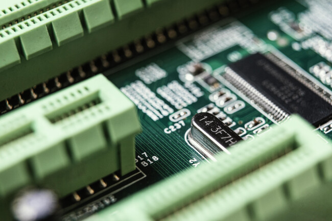 Close-up of a green circuit board with microchips and connectors