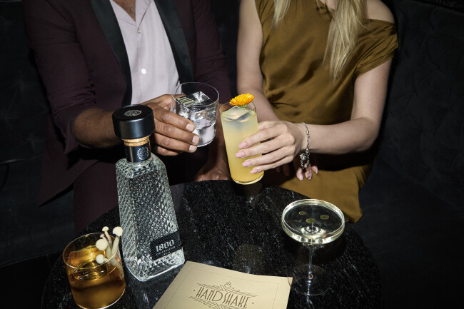 The 1800 Cristalino Tequila bottle with the new signature cocktail at a bar table