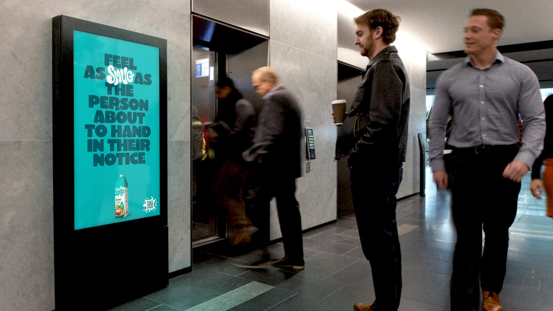 Digital SMUG Dairy ad in an office elevator lobby, featuring playful copy as part of the brand’s contextual OOH campaign.