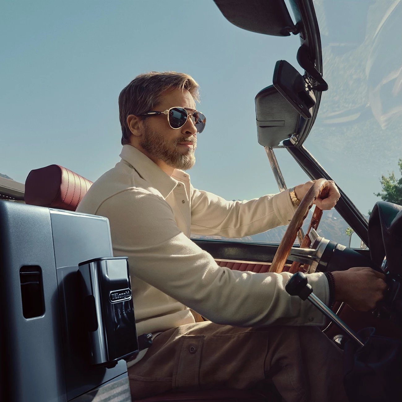 Brad Pitt driving with a De'Longhi coffee machine in the passenger seat