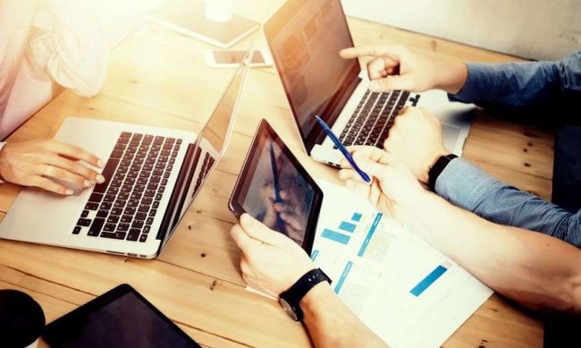Website-improvement-guide-hero-image-opt A team looking for website improvement on the laptop and tablet